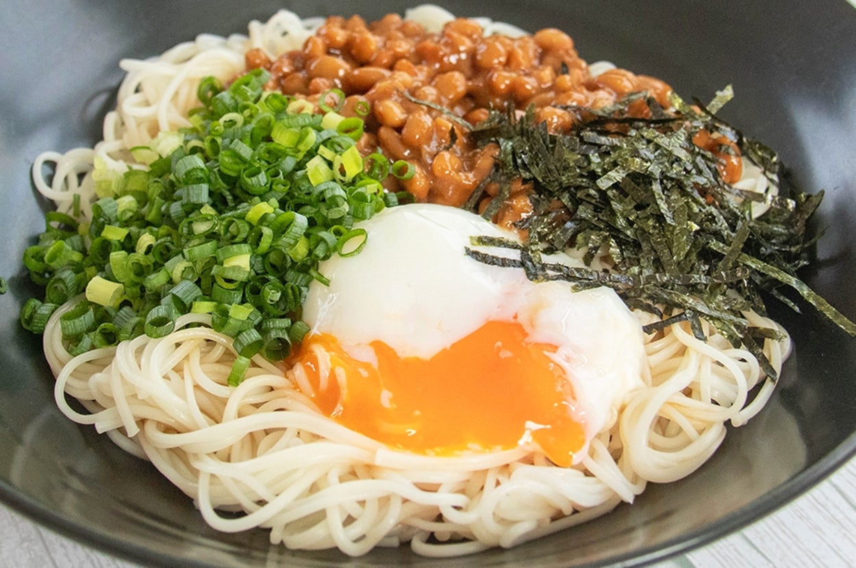 温泉卵、みそ入りの納豆、刻みのり、小ネギがのった混ぜそうめん。