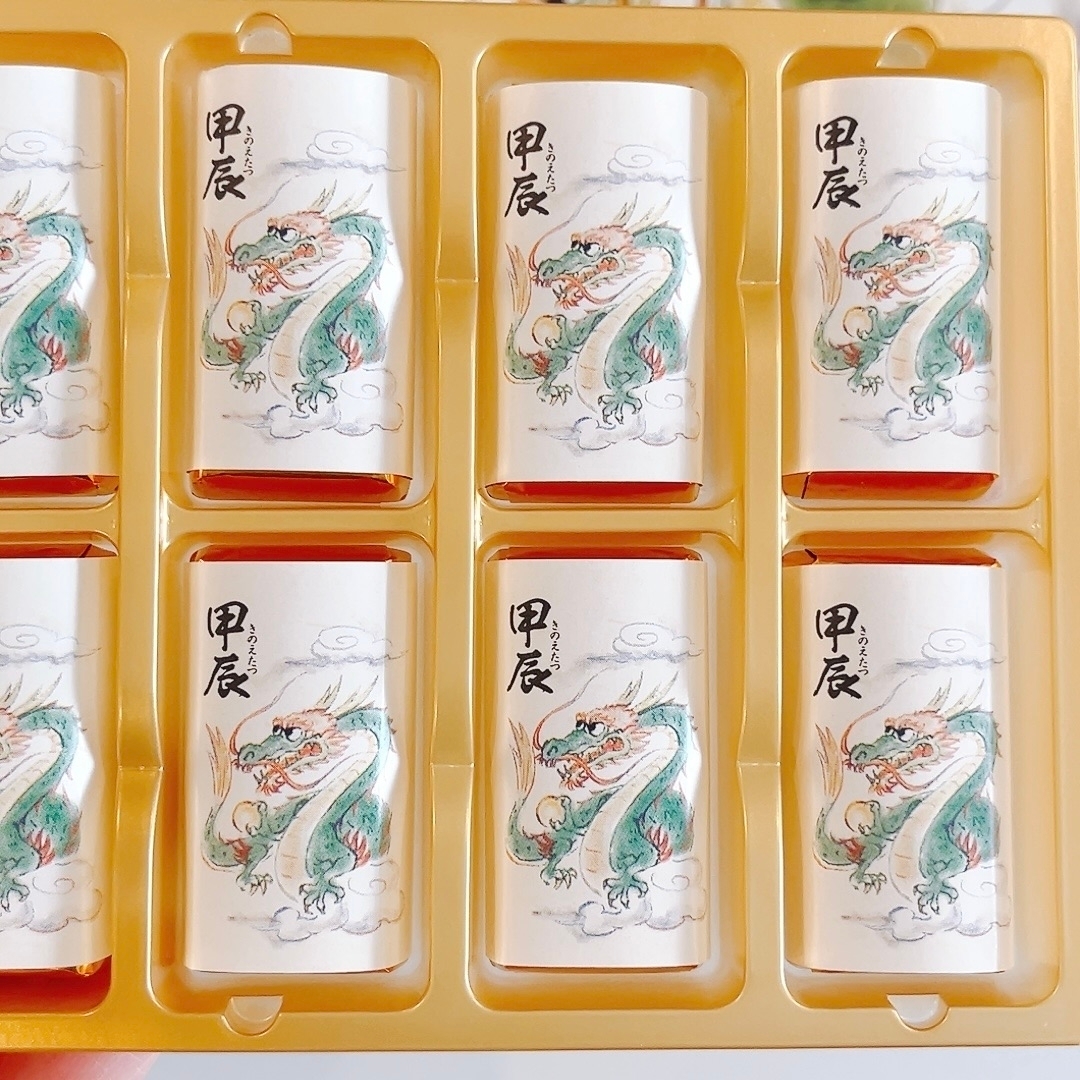 ドラゴンが描かれたパッケージの複数のお菓子がプラスチックトレイに整然と並んでいる。