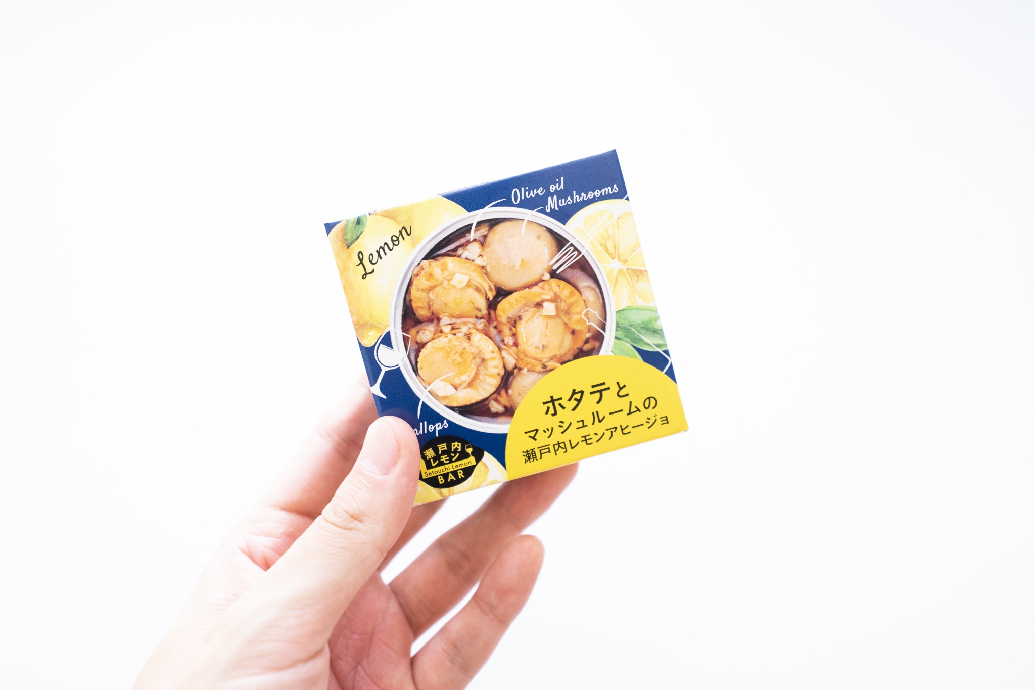 ホタテとマッシュルームの缶詰食品パッケージ、レモンとオリーブオイルの風味が強調されています。