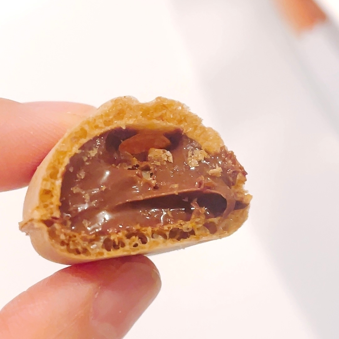 チョコクリームが入ったクッキーを半分に割った状態で手に持っています。