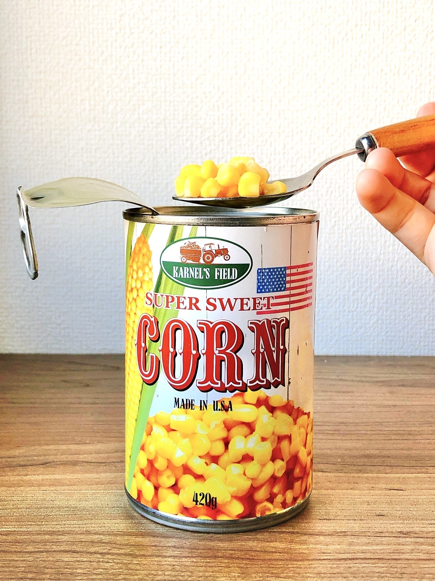 缶詰のスイートコーンが開けられ、フォークでコーンがすくわれている。カーネルズフィールドの製品。