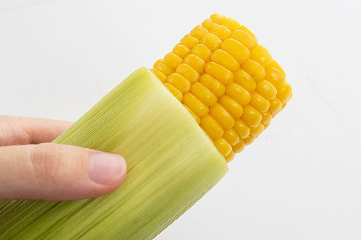 とうもろこしの皮をむいて持っている様子。