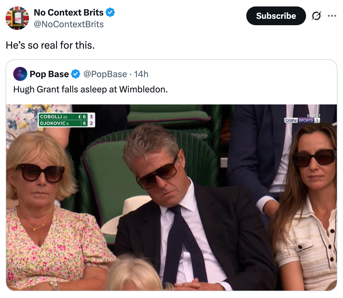 Two people with sunglasses sit beside a man in a suit, also wearing sunglasses, asleep at a tennis match