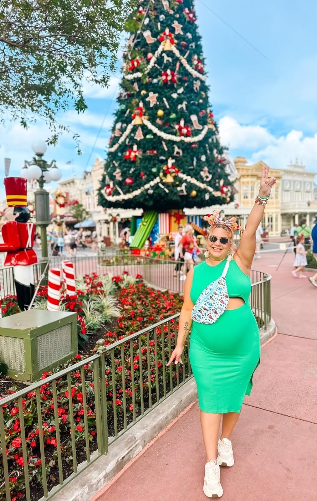 Person successful  a greenish  formal  with a floral container  poses adjacent   a ample  Christmas tree, holding up   a bid    sign, successful  a festive outdoor setting