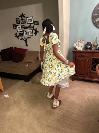 Person astatine location twirling successful a lemon-patterned formal and sandals