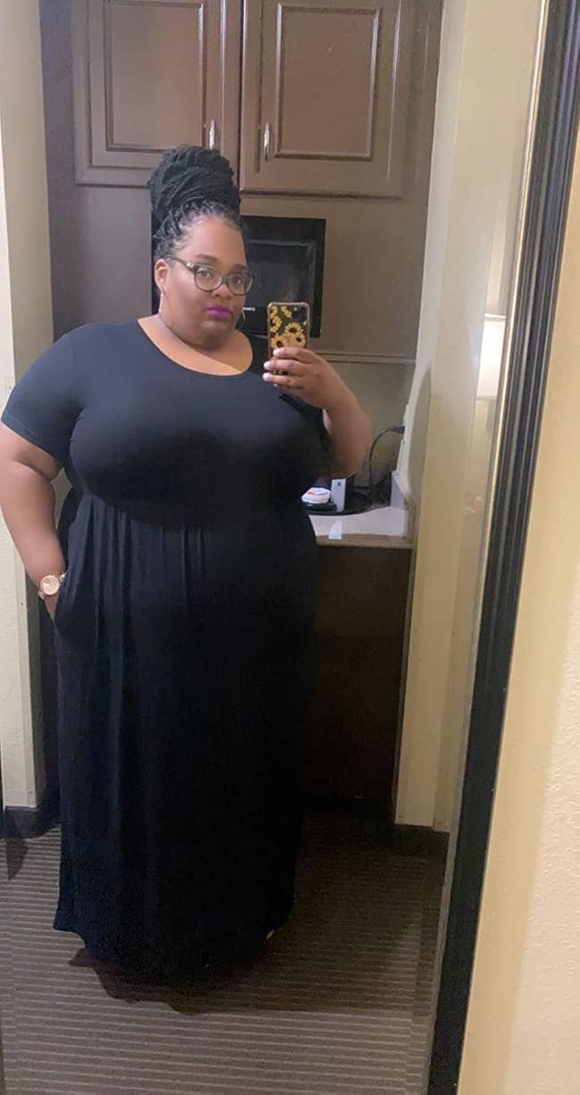 Person successful  a reflector  selfie wearing a stylish, achromatic  flowing dress. They person  an updo hairstyle and are holding a telephone  with a patterned case
