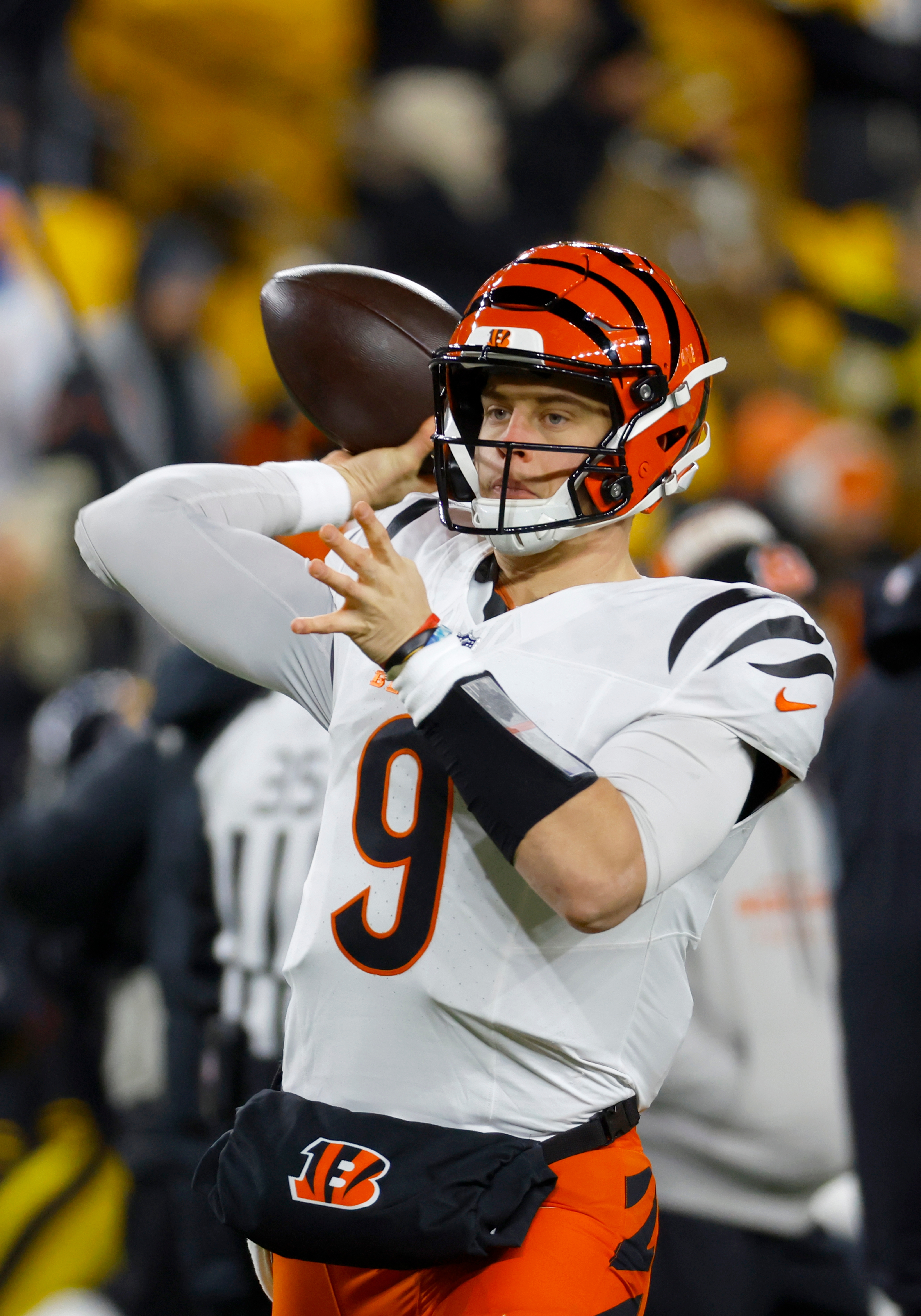 Joe Burrow throwing a football on the field during a game
