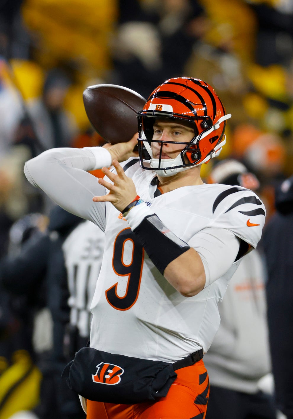 Joe Burrow throwing a football on the field during a game