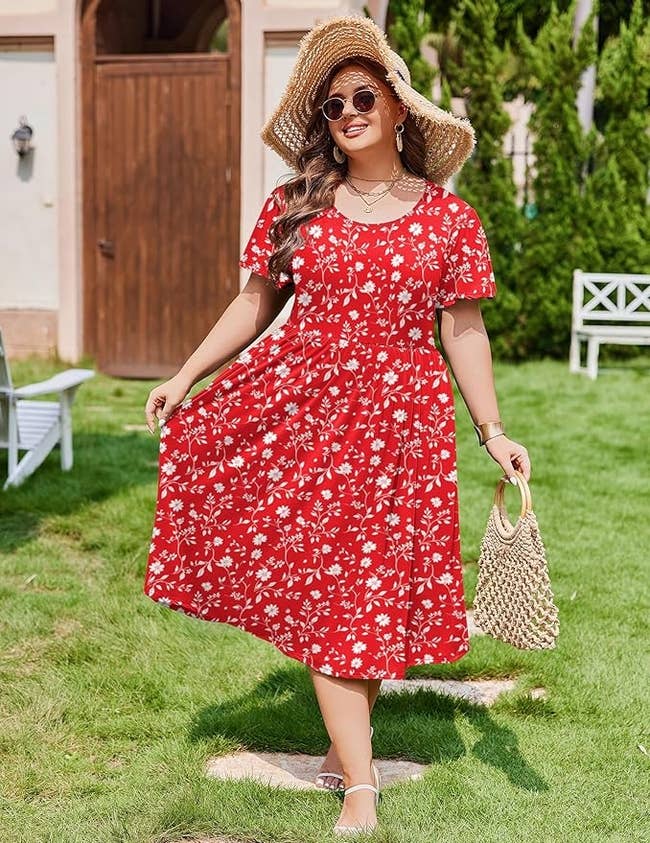 Model successful  reddish  floral dress, straw hat, and sunglasses poses successful  plot  with woven bag, showcasing a casual summertime  outfit