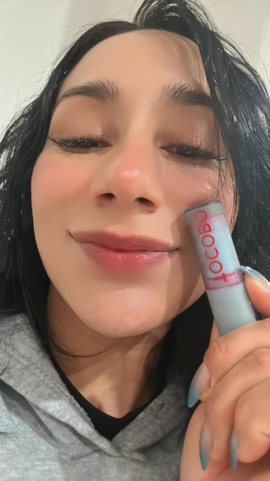 Person smiling and holding a articulator  balm conduit  labeled 