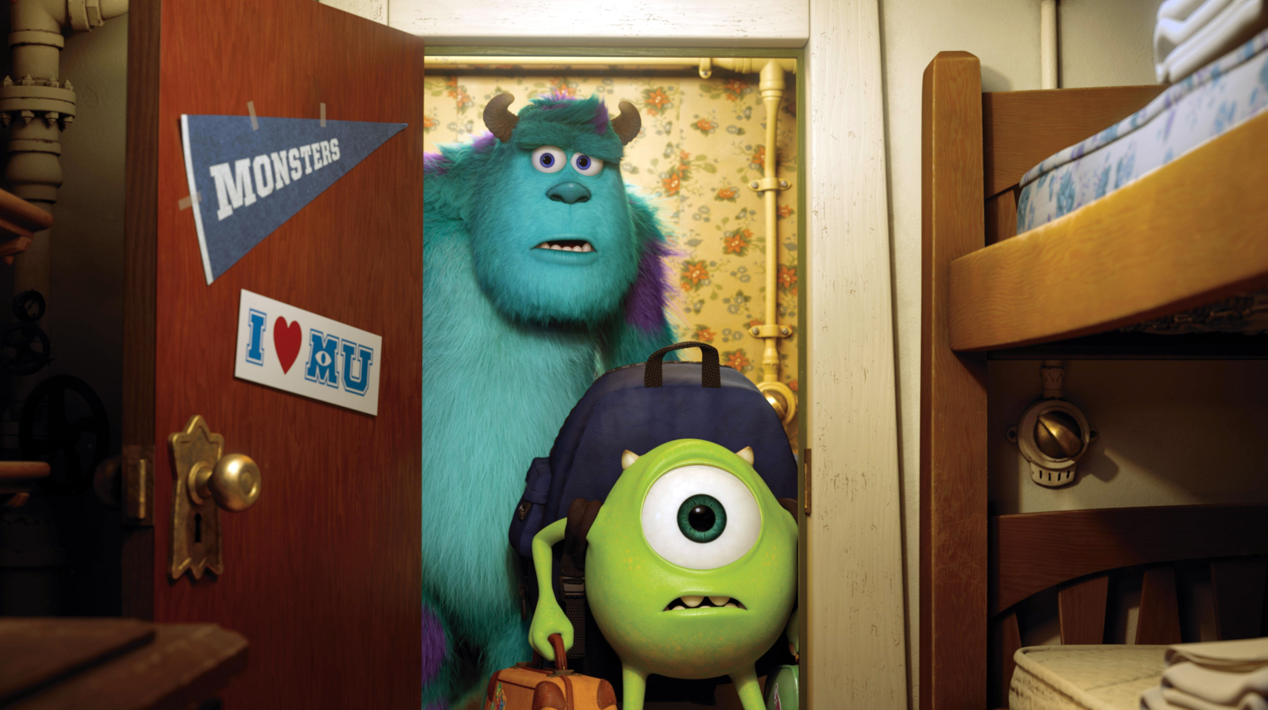Animated characters Sulley, a large furry monster, and Mike, a small round monster with one eye, stand in a doorway holding suitcases