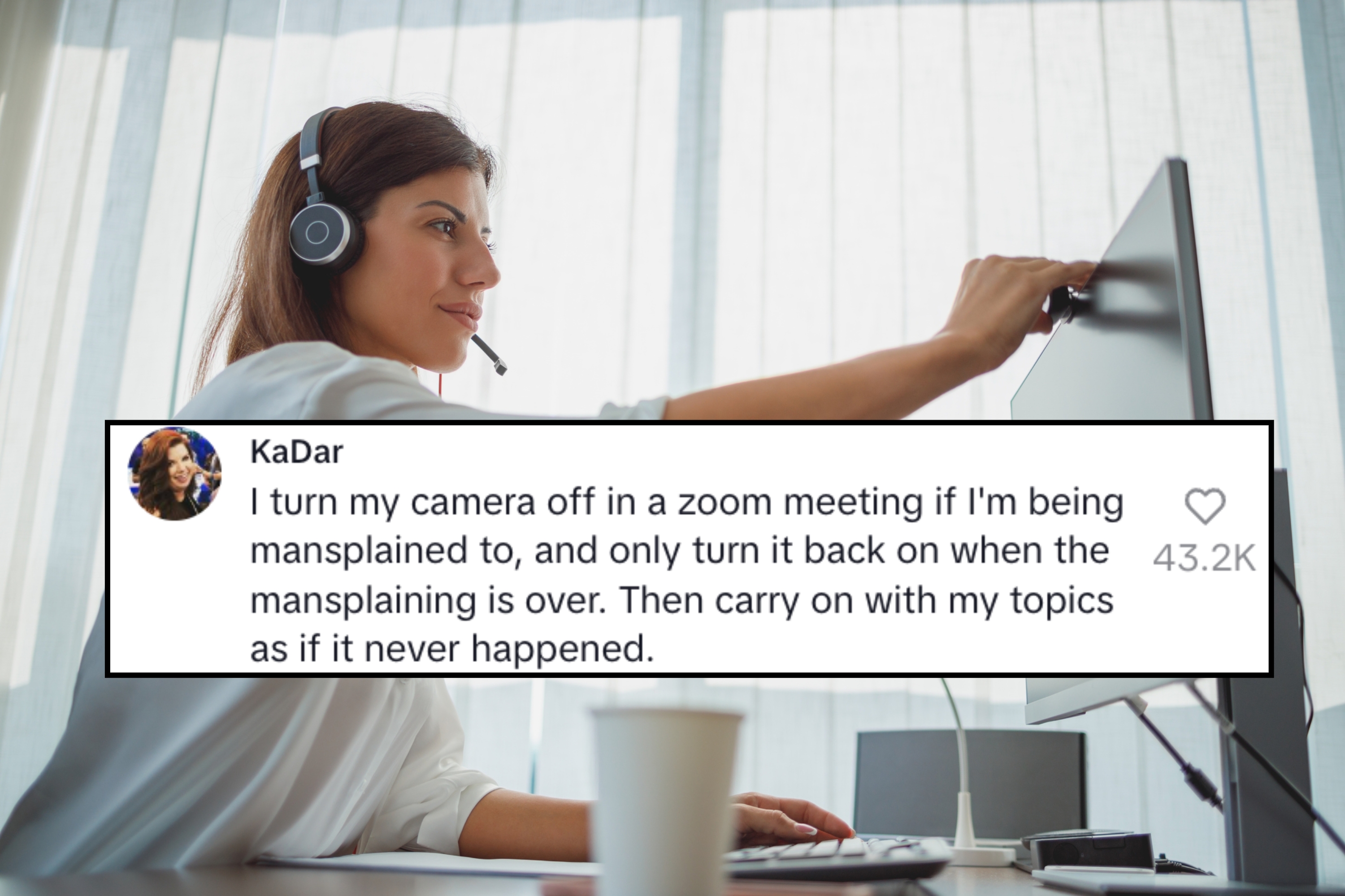 En smilende person som har på seg et headset, justerer en dataskjerm i en kontorinnstilling, med en kopp på skrivebordet i forgrunnen