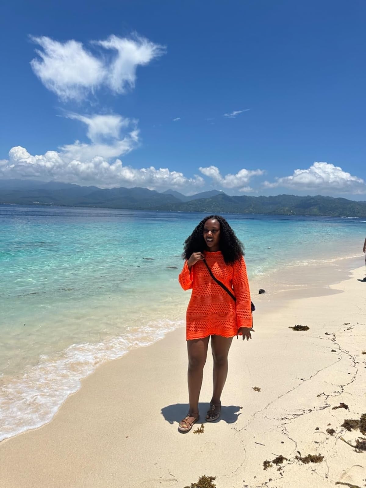 Person connected  a sandy formation  wearing a crochet cover-up and sandals