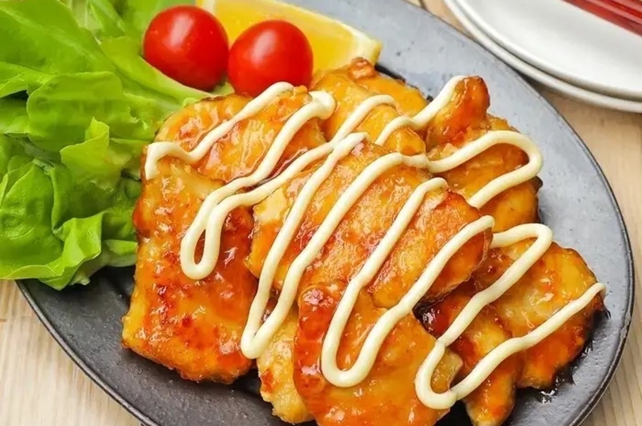 皿に盛られた焼き鶏にマヨネーズがかかり、レタスとトマトが添えられている。