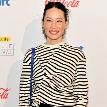 Person wearing a striped top and black pants, smiling at a public event