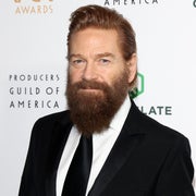 Person in a black suit and tie at a Producers Guild event