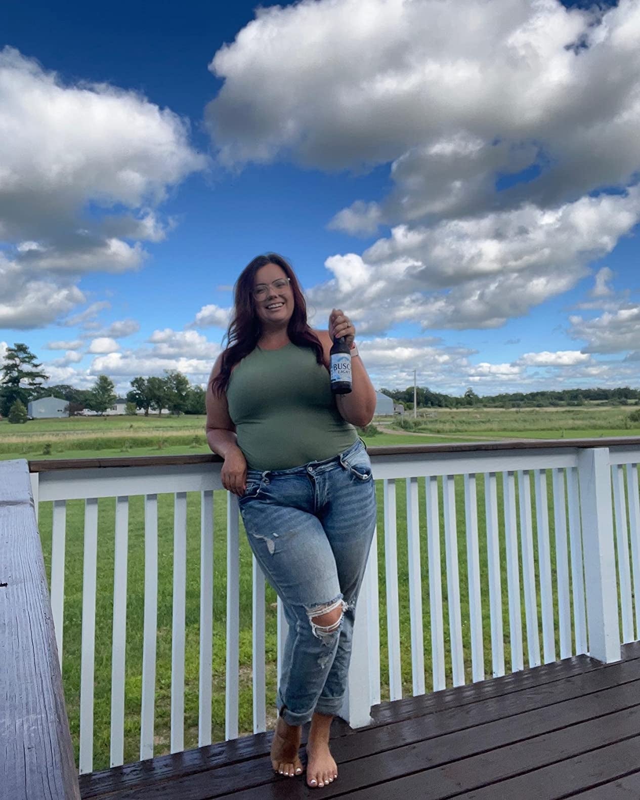 Person connected  a platform  holding a beverage bottle, wearing a casual apical  and ripped jeans