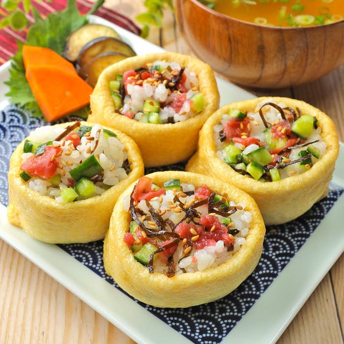 寿司揚げで包まれたリゾットスタイルの料理が4つ並んでおり、野菜とスープが添えられています。
