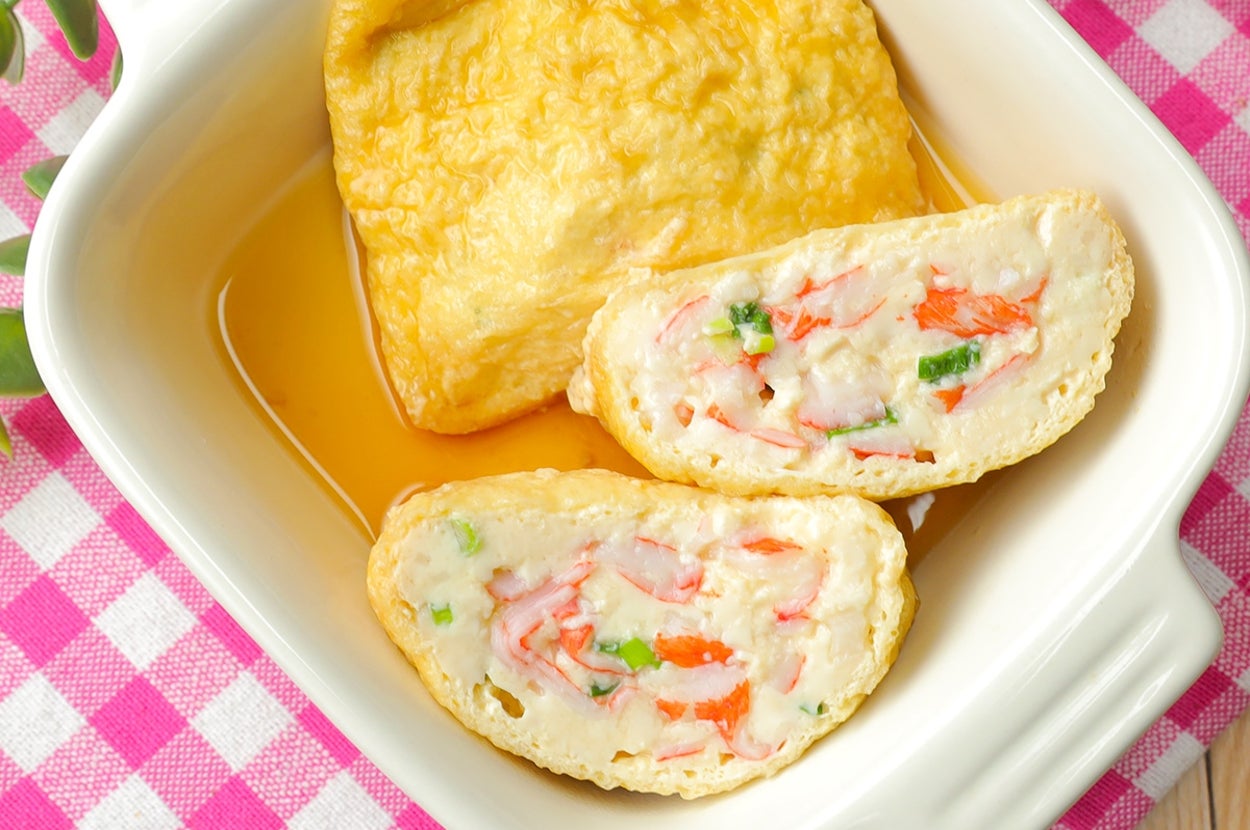 皿に盛られたカニカマ入り卵焼きと揚げの料理。横にお箸が置かれている。