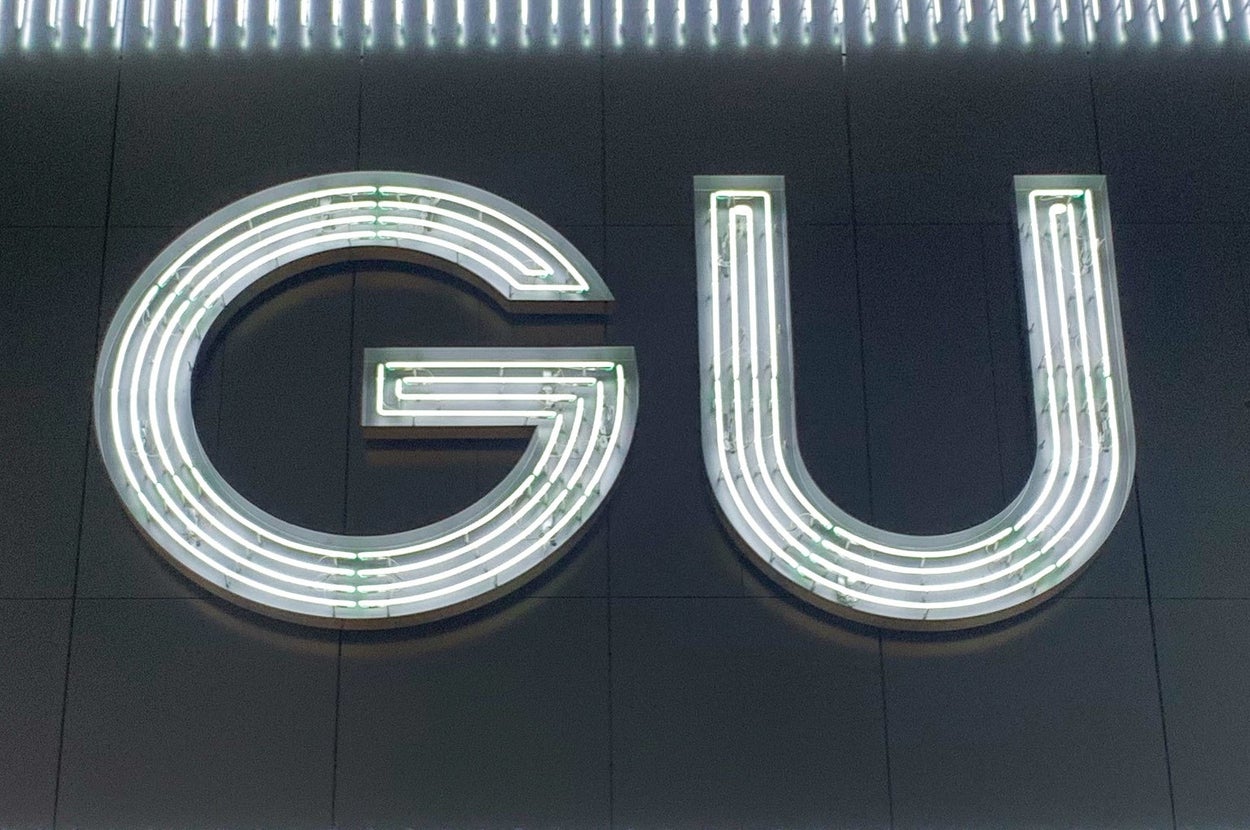 GUのネオン看板が夜の壁に取り付けられている様子。