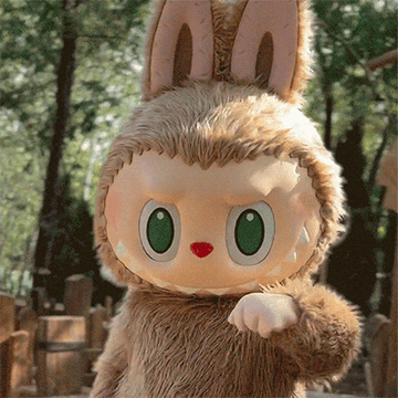 A person in a plush bunny costume with large eyes gestures forward in an outdoor setting
