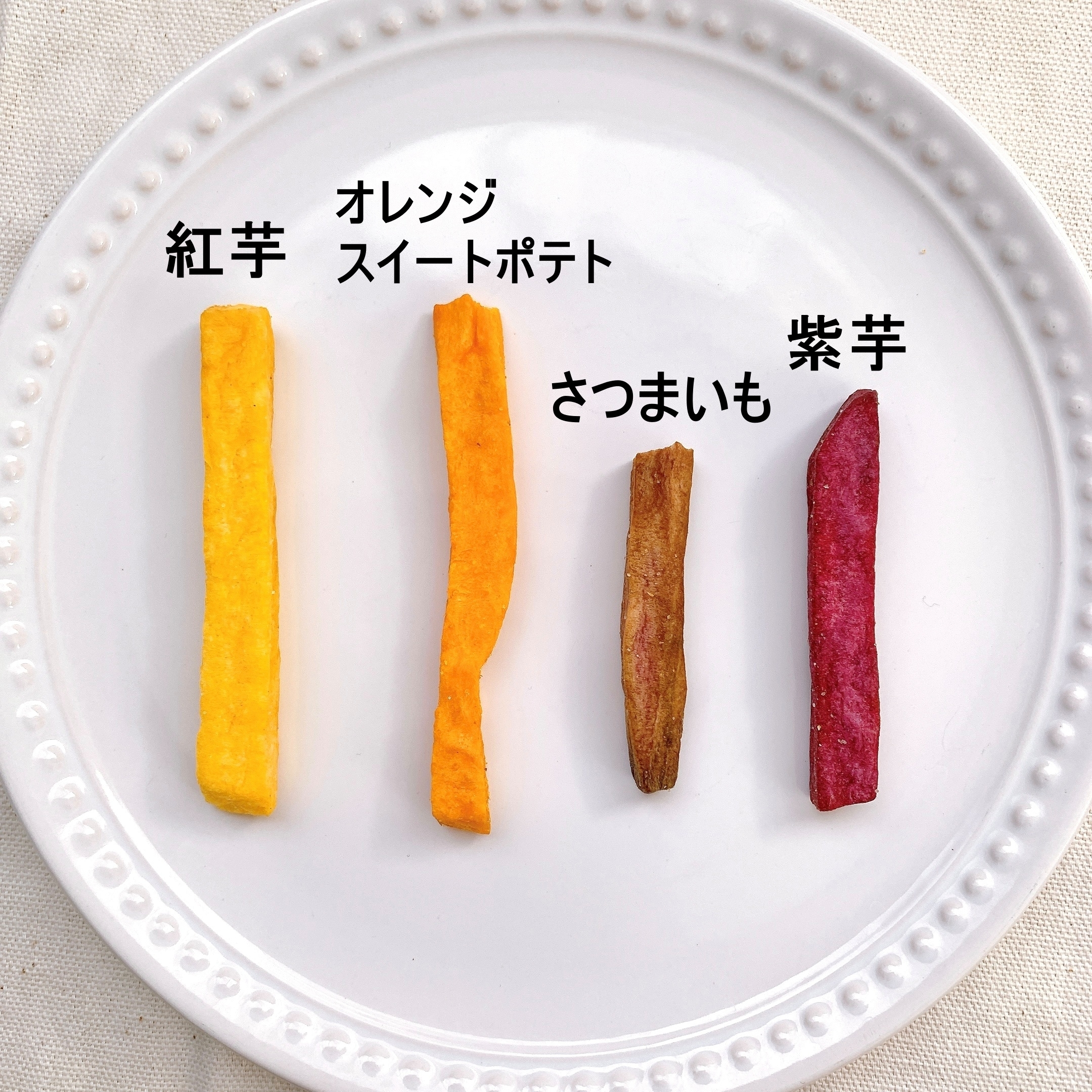 異なる種類のさつまいもフライが4本、皿の上に並べられ、それぞれの種類が日本語でラベル付けされています。