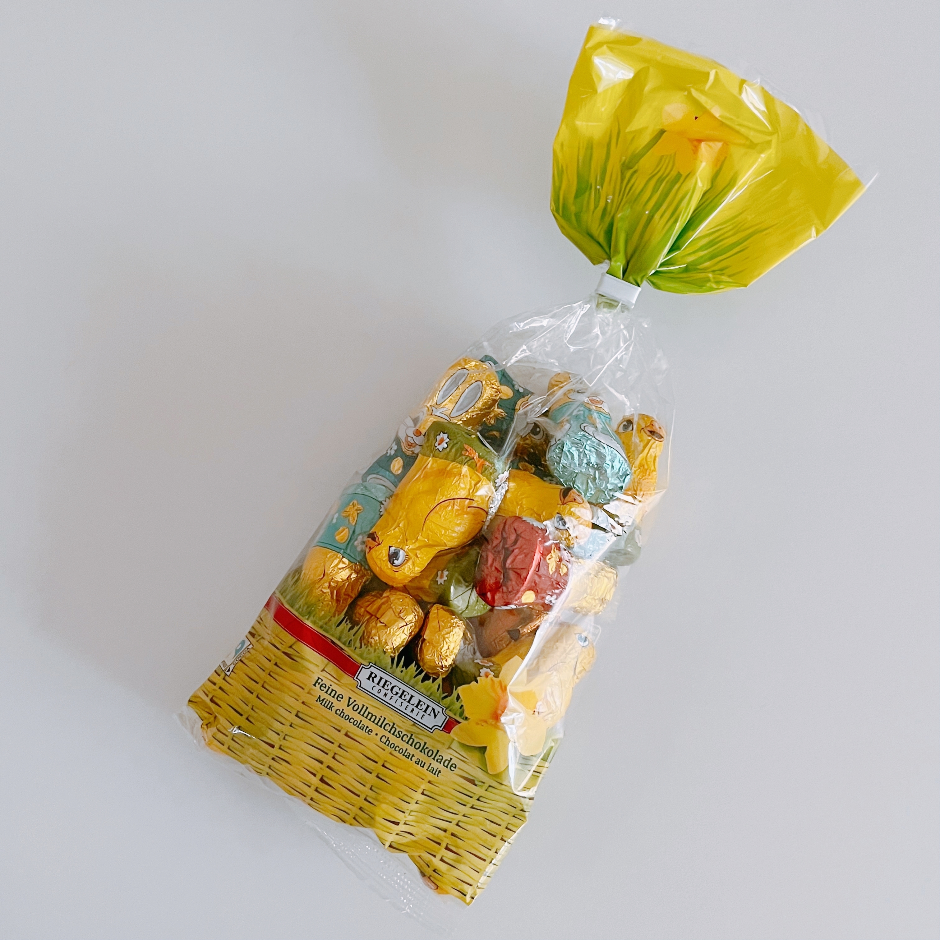 透明な袋に詰められたチョコレート菓子のアソートパック。袋の上部には黄色い花のデザイン。