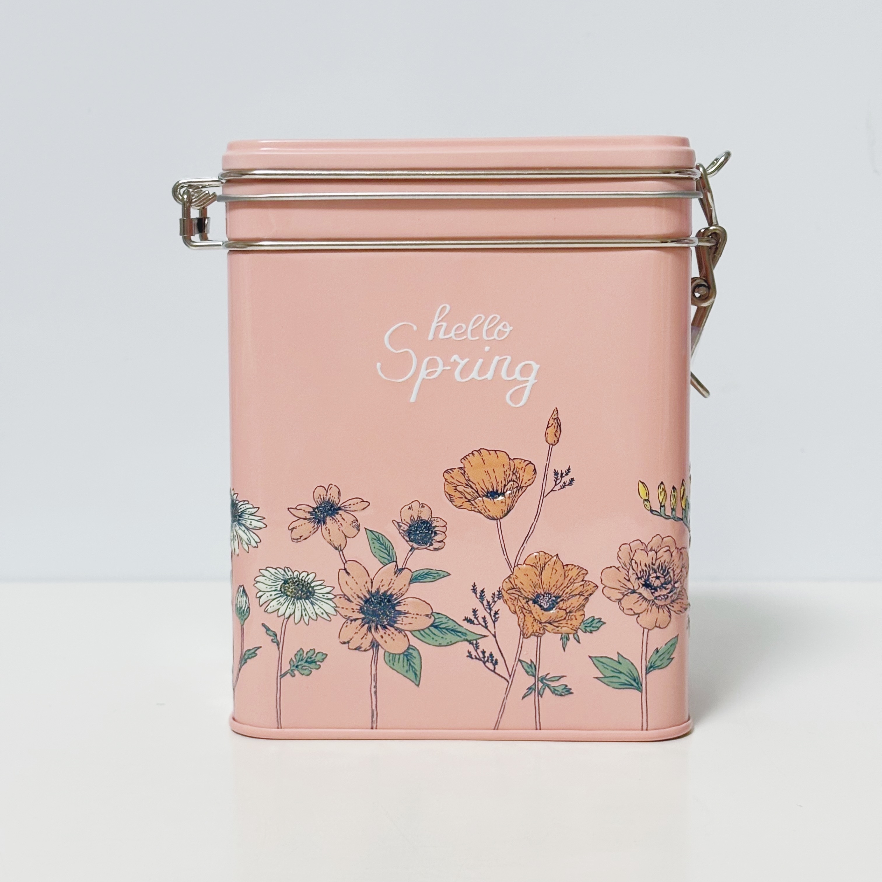 花のイラストと「hello Spring」の文字が描かれた金属缶。