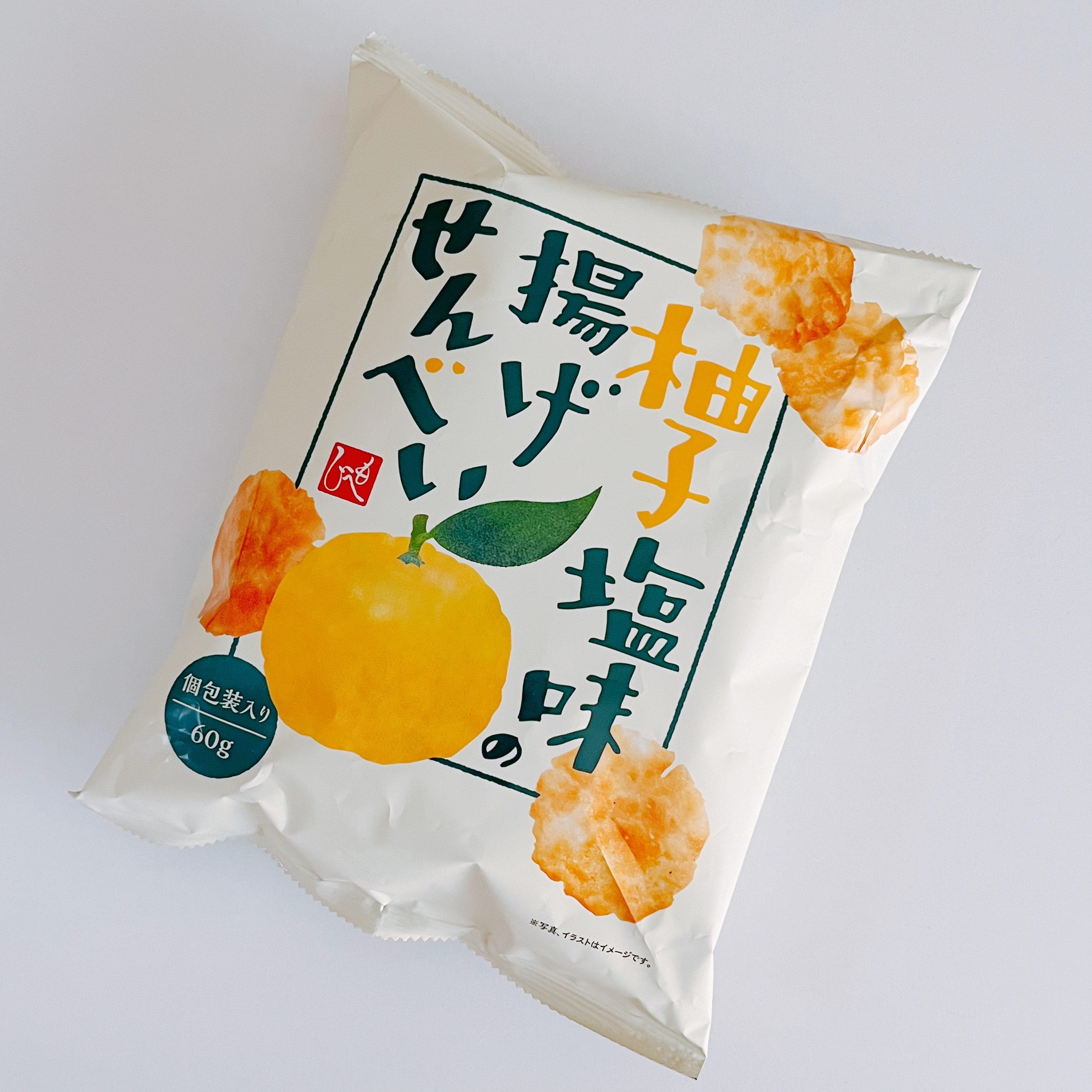 袋入りの柚子塩味せんべいがテーブルに置かれている。包装に柚子のイラストと商品名が書かれている。