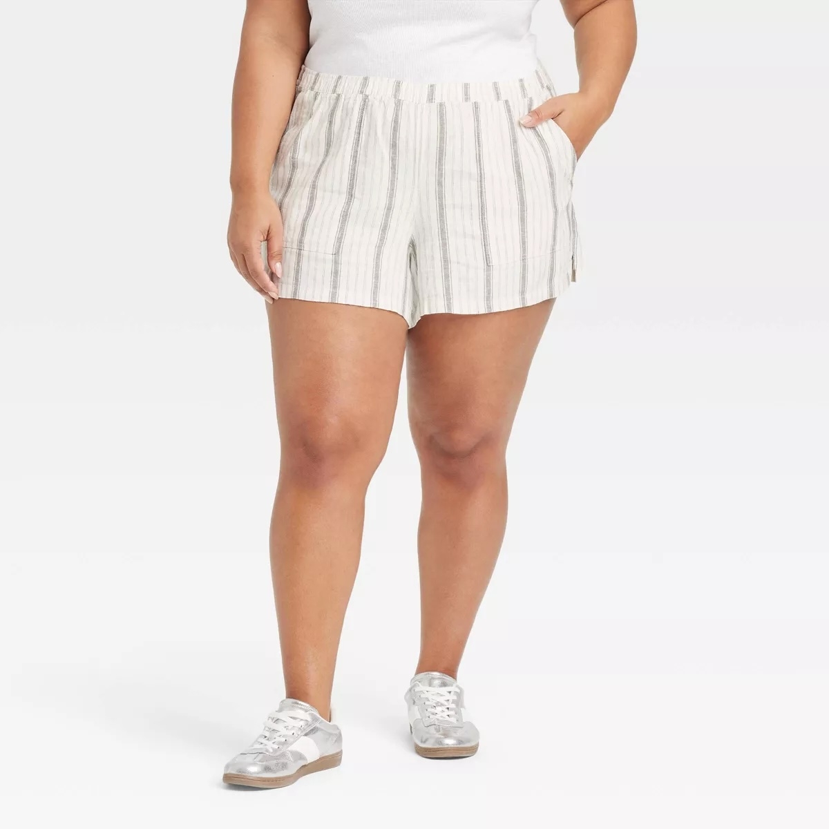 Person wearing striped shorts and sneakers, paired with a plain top