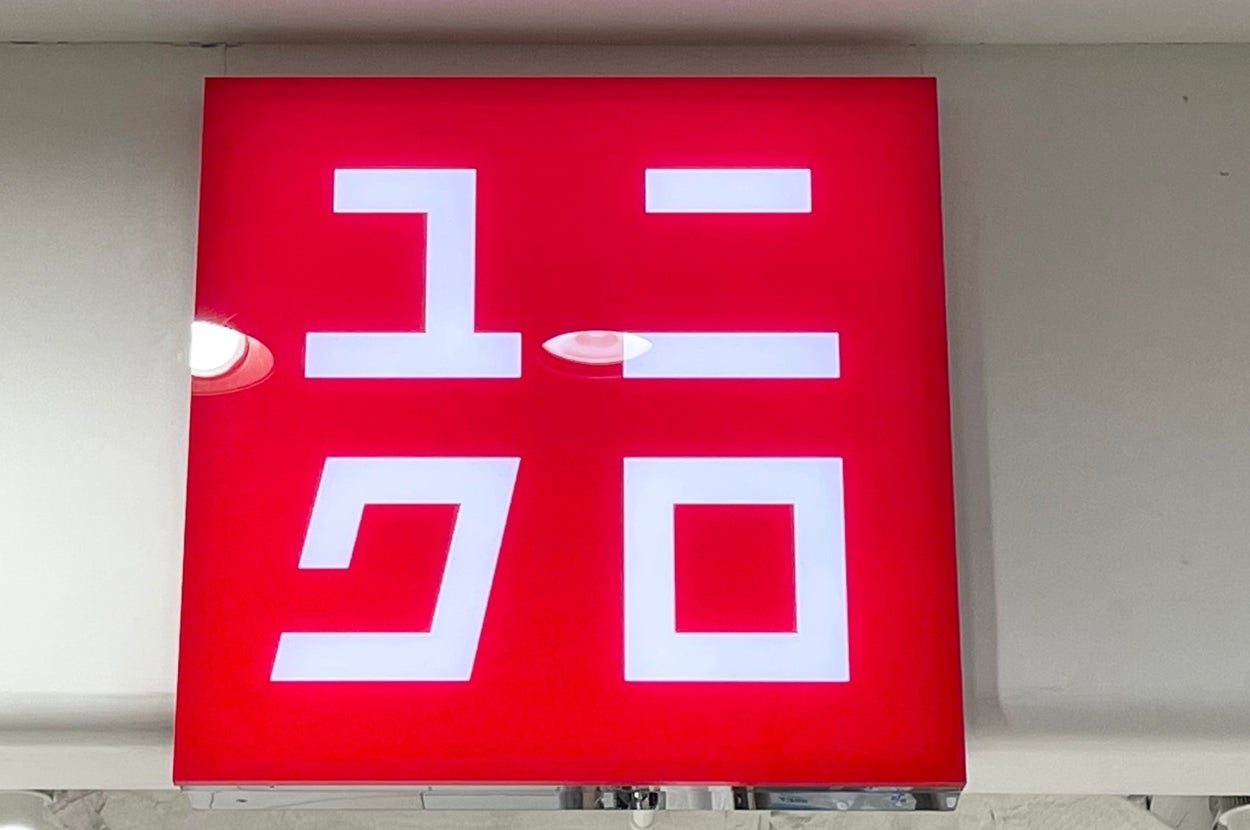 A red Uniqlo store sign with white Japanese characters displayed above a store entrance