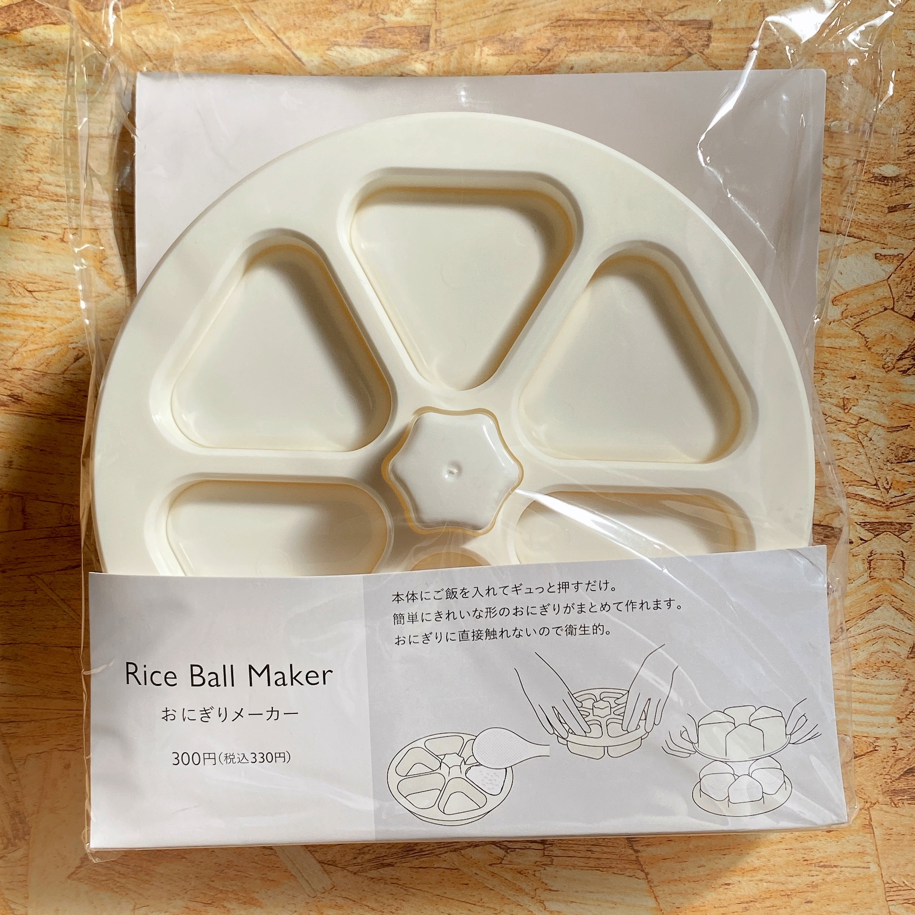 おにぎりメーカーのパッケージ。1回で5個の三角形おにぎりを作れるデザインが描かれている。価格は300円(税込)。