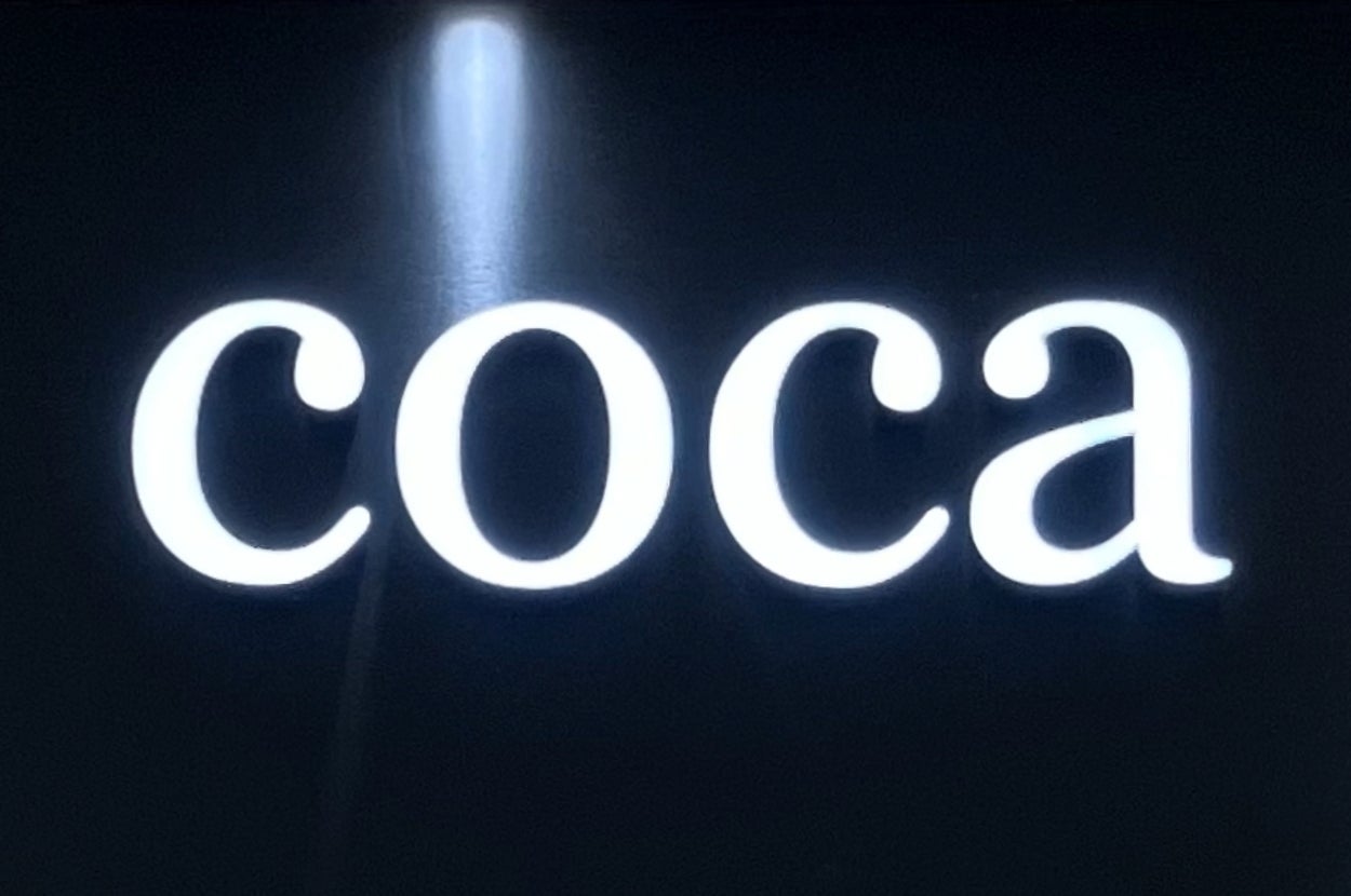 店舗の看板に「coca」の文字。