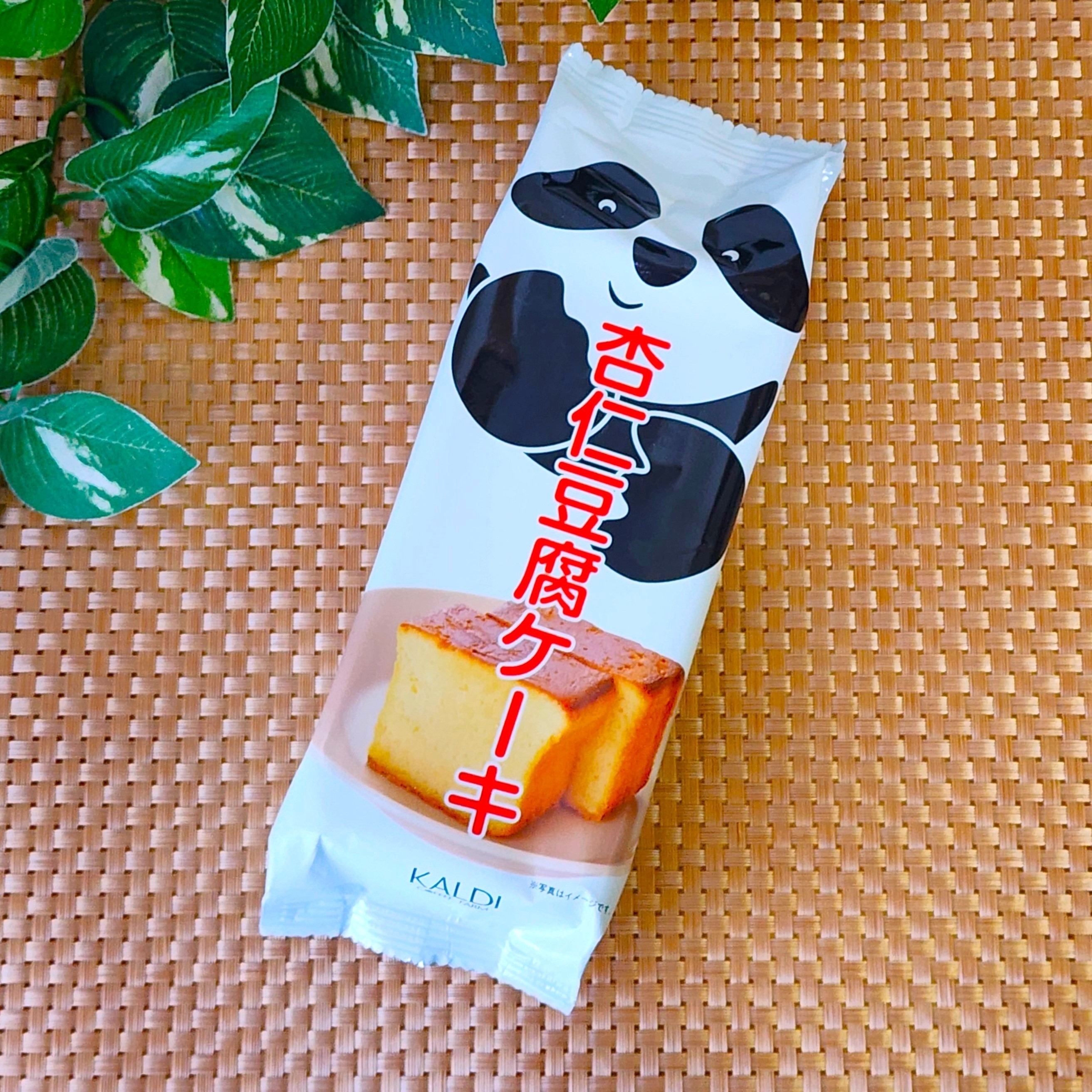 パンダのイラストが描かれた包装の杏仁豆腐ケーキ。緑の葉が横に添えられています。