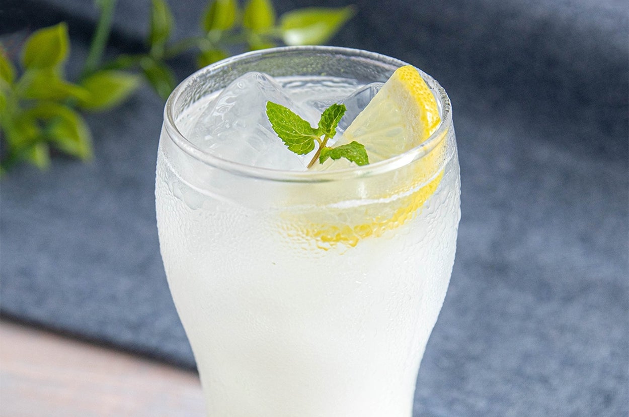 氷とレモン、ミントが入った冷たい飲み物のグラスがテーブルに置かれている。