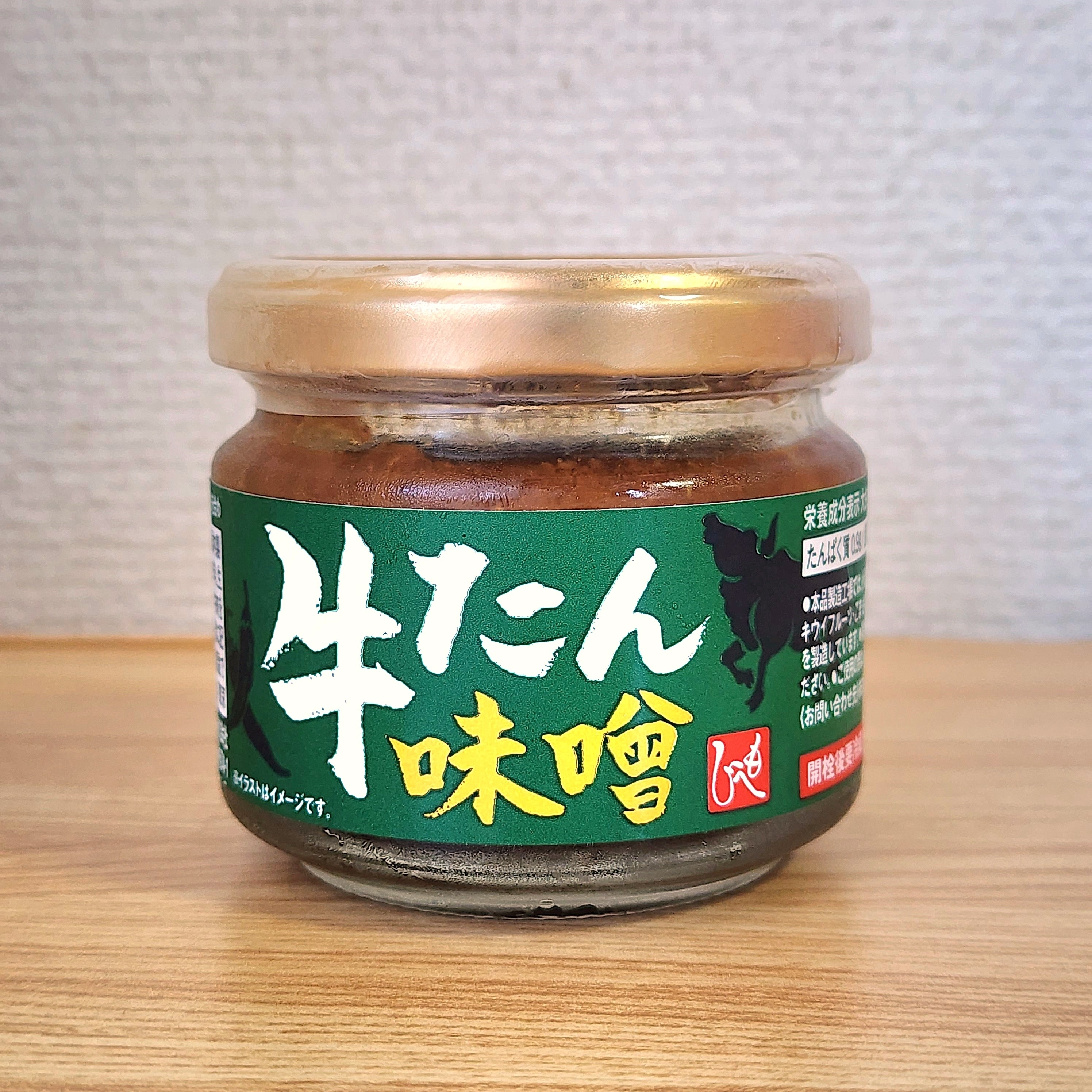 牛たん味噌の瓶、テーブル上に配置。ラベルにはイラストや説明書きがある。