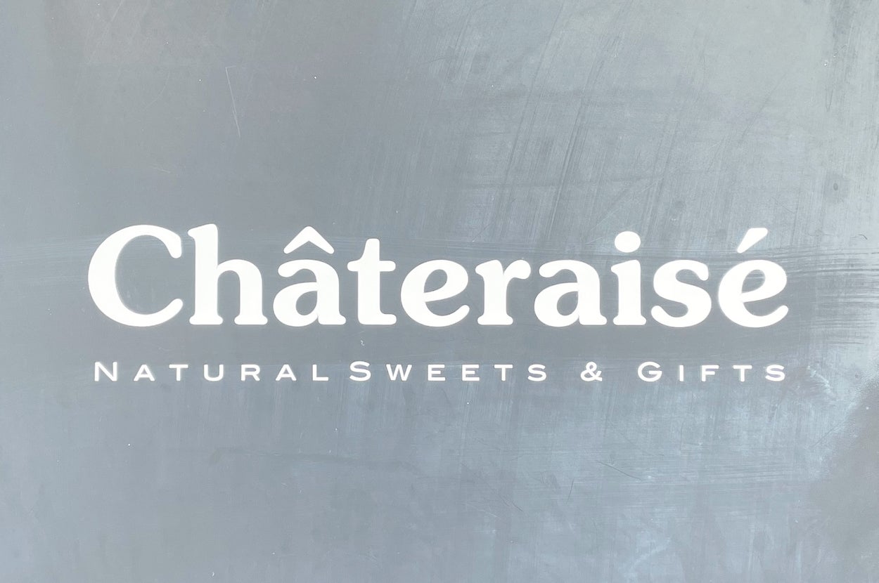 シャトレーゼの看板。「NATURAL SWEETS & GIFTS」と書かれています。