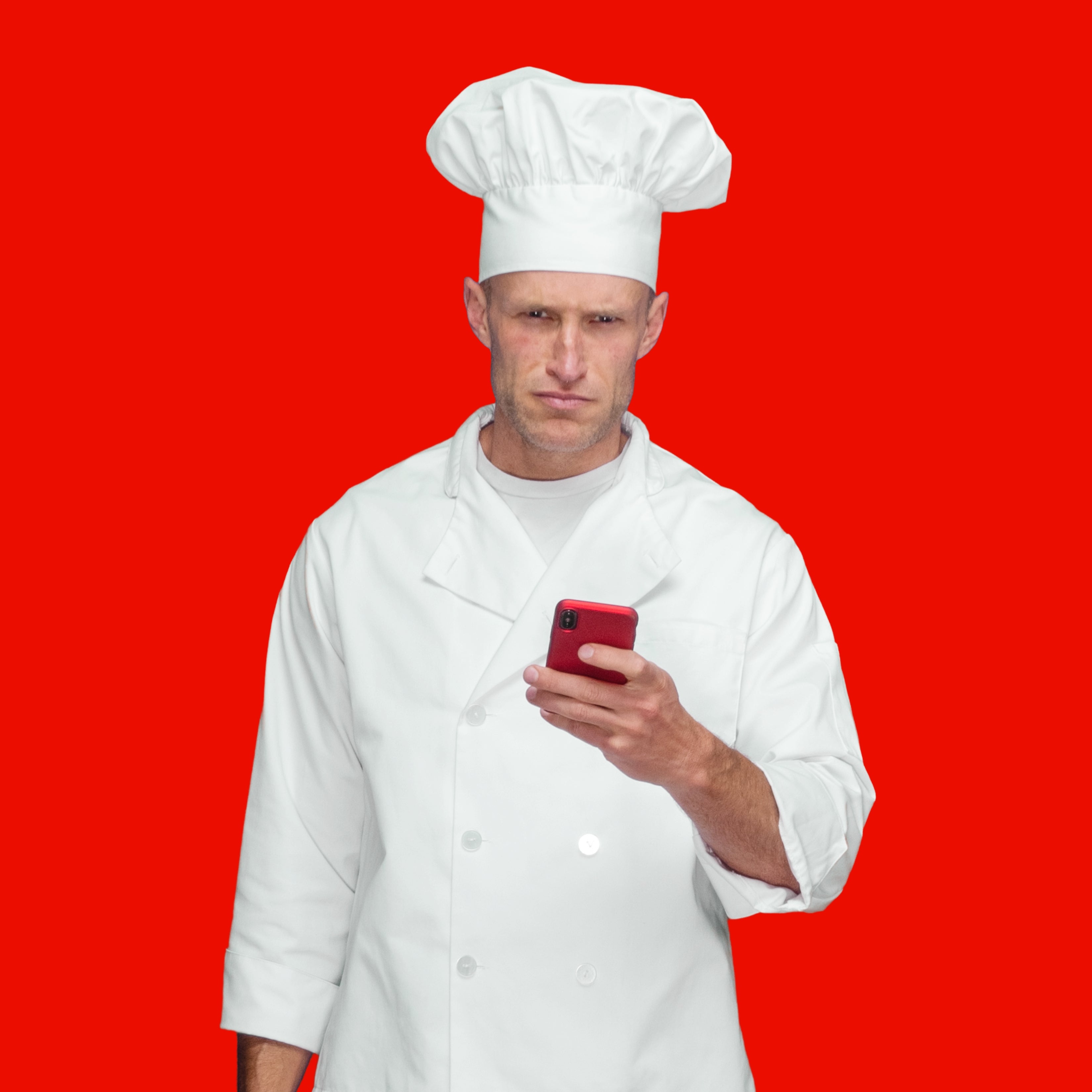 Koki berseragam dan topi melihat telepon dengan latar belakang merah
