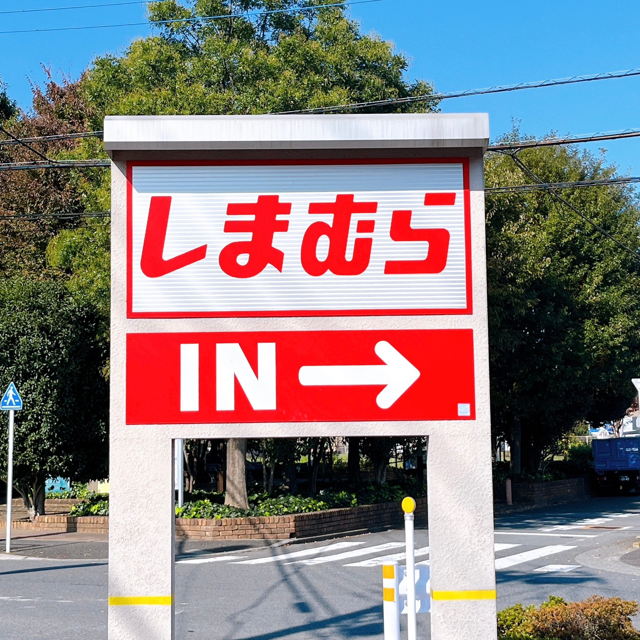 しまむら店舗の駐車場案内看板。矢印が駐車場入り口を示している。