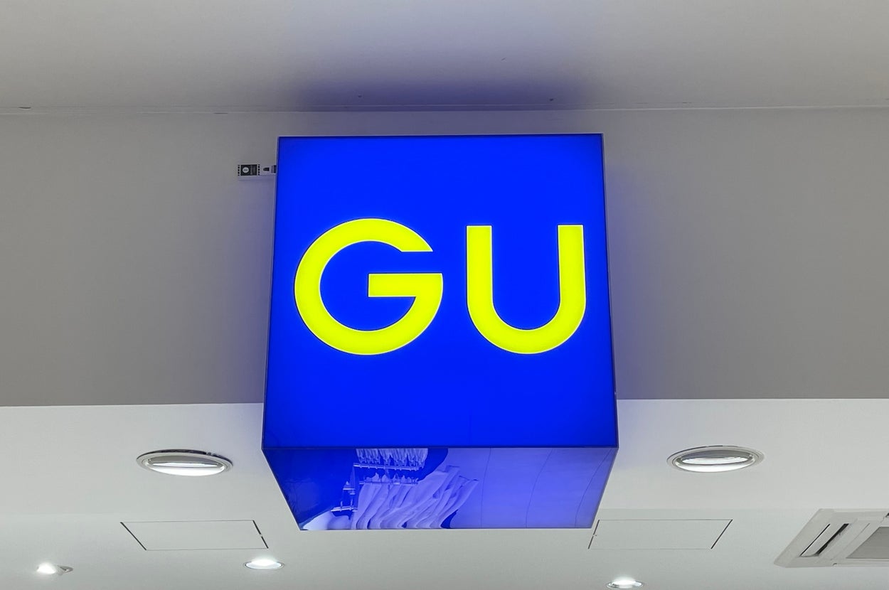 Store sign with bold letters reading "GU" on a bright background