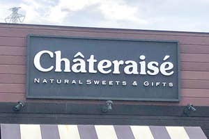 シャトレーゼの店舗看板。「NATURAL SWEETS & GIFTS」と記載されている。