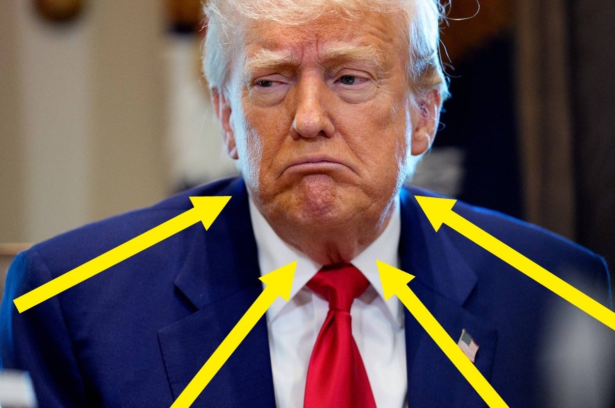 A person in a suit and red tie looks concerned with several yellow arrows pointing at them
