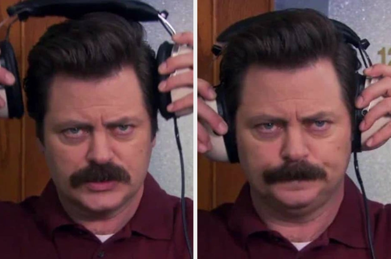 A man with a mustache adjusts headphones on his head. His expression is focused
