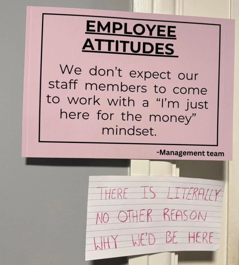 Sign on a wall says employees shouldn&#x27;t have a &quot;here for the money&quot; mindset. A handwritten note below counters: &quot;That&#x27;s the only reason we&#x27;re here.&quot;