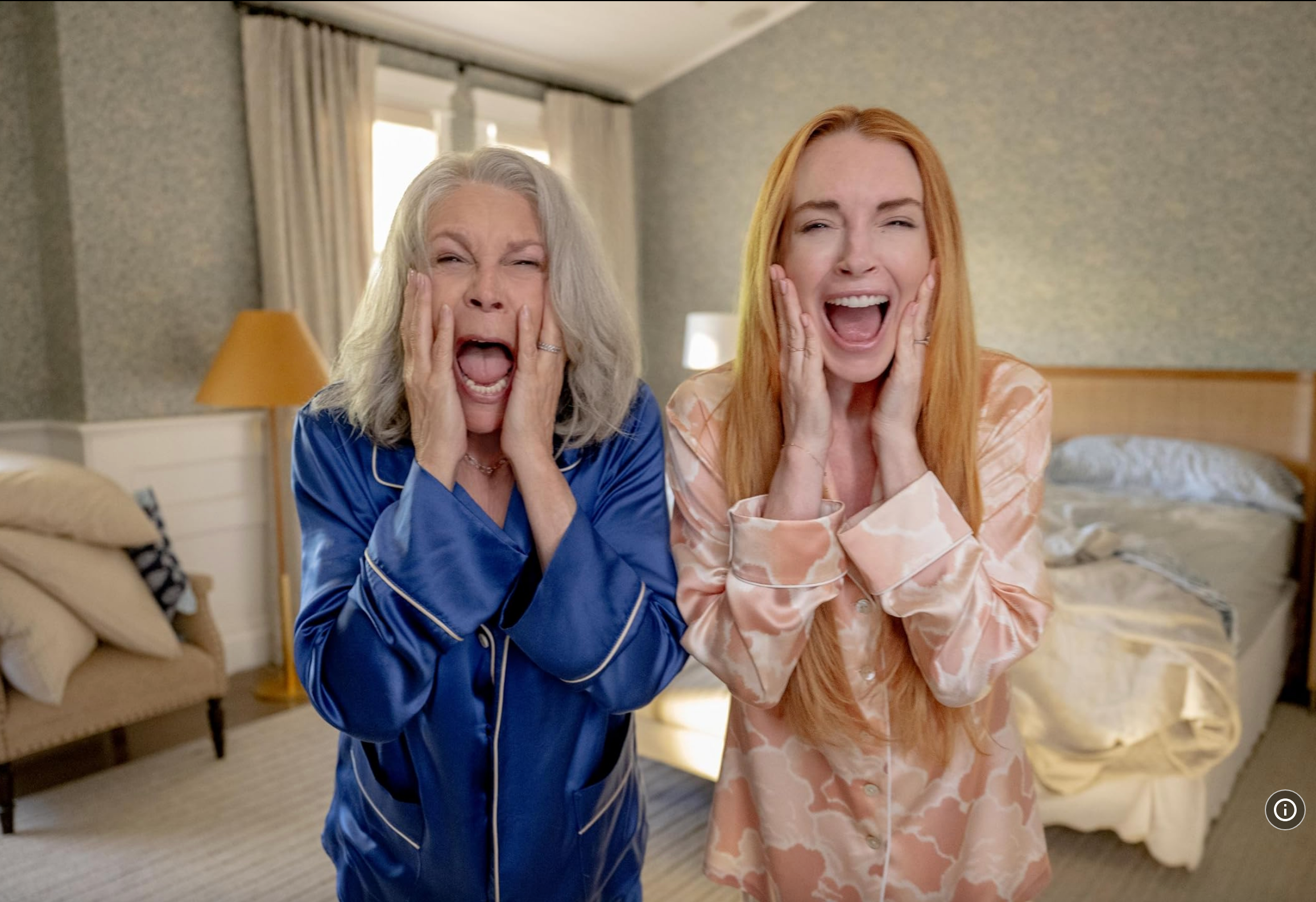 Two people in a bedroom wearing pajamas with surprised expressions, hands on their faces