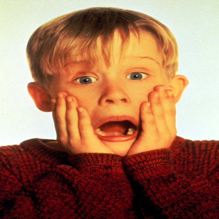 Child actor with surprised expression, hands on cheeks, wearing a knitted sweater