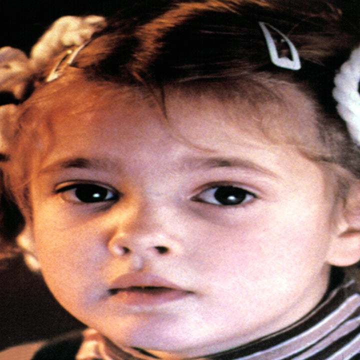 A child with curly hair in pigtails, wearing a striped shirt