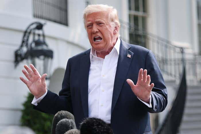 Trump speaking passionately to media outside the White House, gesturing with both hands near microphones