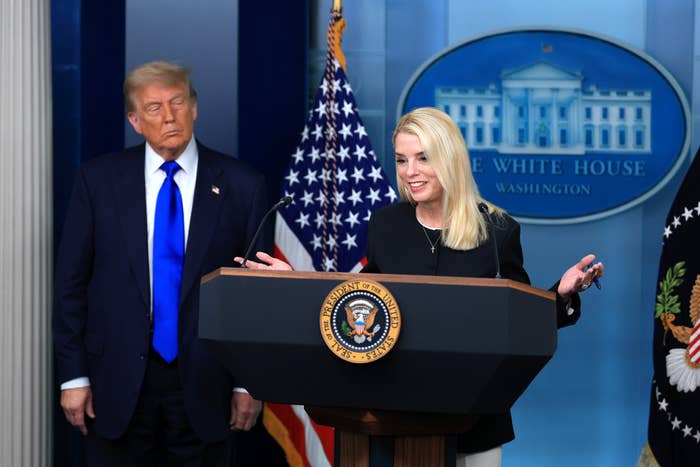 Pam Bondi speaks at a White House press briefing with Trump standing behind her