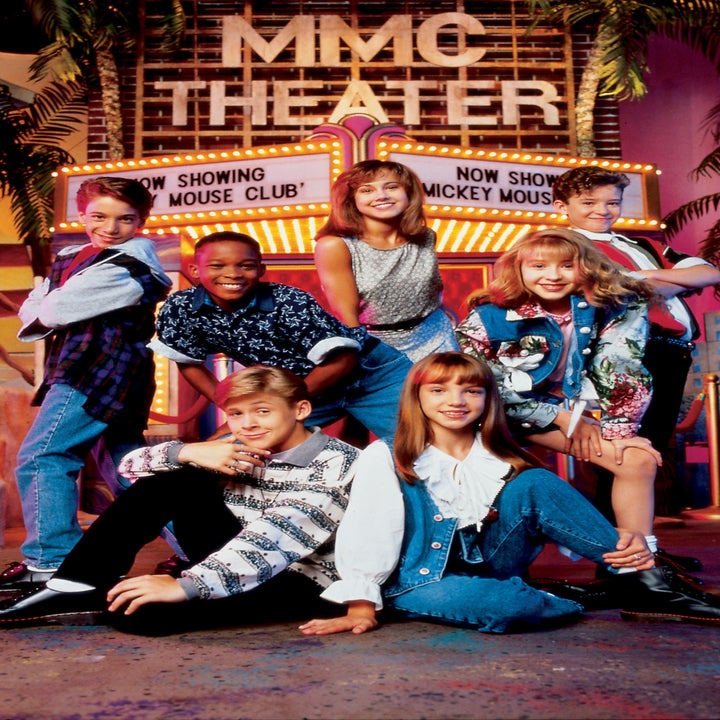 Group of young performers posing cheerfully in front of the "MMC Theater" marquee, wearing casual 90s-style outfits